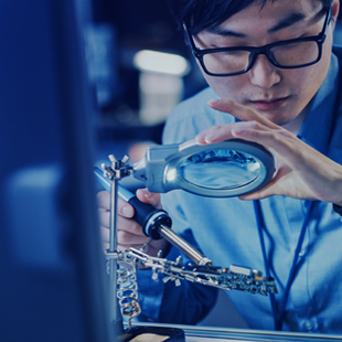 Person with glasses looking through a magnifying glass