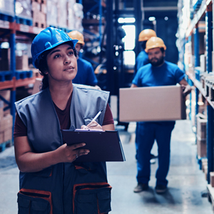 People in hard hats taking invetory of a supply warehouse